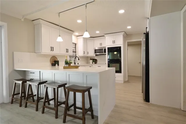 a kitchen with stainless steel appliances a sink a stove a refrigerator and cabinets