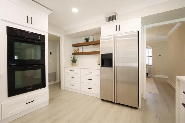 a large kitchen with a lot of counter space and a wooden floor