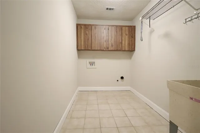 a spacious bedroom with a bed a chandelier and a couch