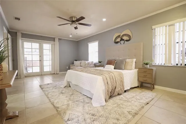a bedroom with a large bed a rug and windows