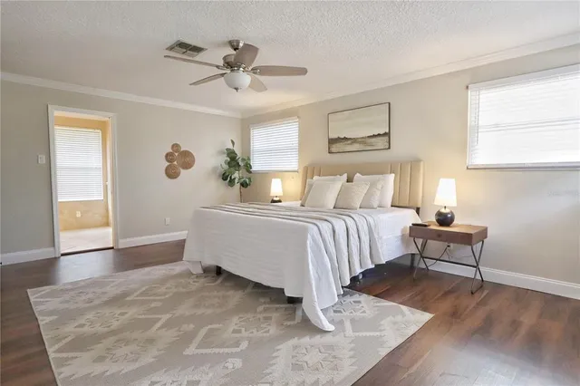 a spacious bedroom with a bed and a chandelier