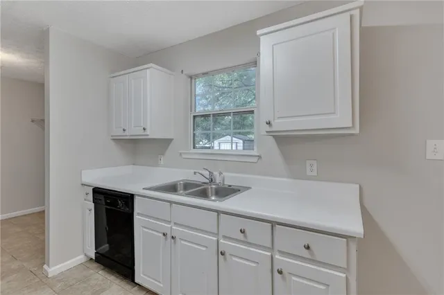 a kitchen with white cabinets and a sink
