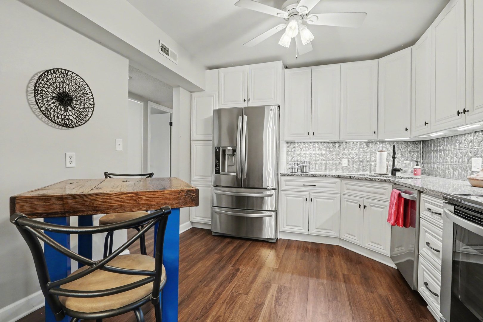 1423 Woodbridge Road, Unit 1E Joliet, IL 60436 - Photo 8 of 30 a kitchen with stainless steel appliances granite countertop a white cabinets and wooden floor