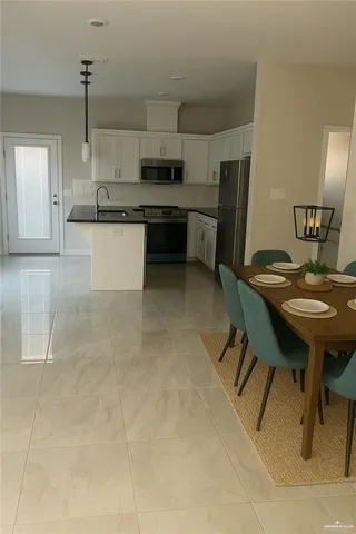a kitchen with kitchen island a stove a table and chairs in it