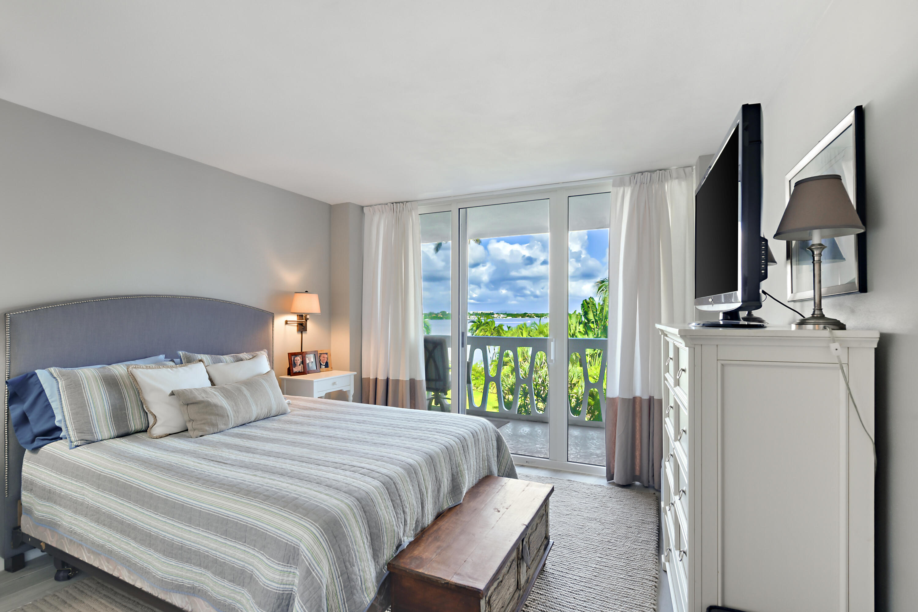 2505 South Ocean Boulevard, Unit 411 Palm Beach, FL 33480 - Photo 14 of 31 a bedroom with a bed a flat tv screen and a window