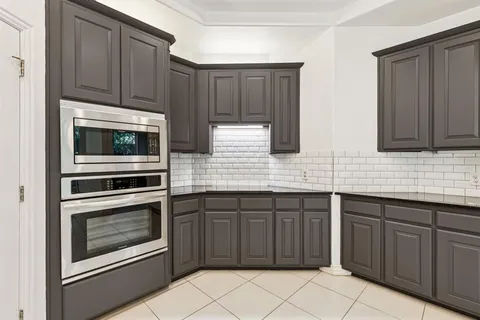 a kitchen with stainless steel appliances granite countertop wooden cabinets and a stove top oven
