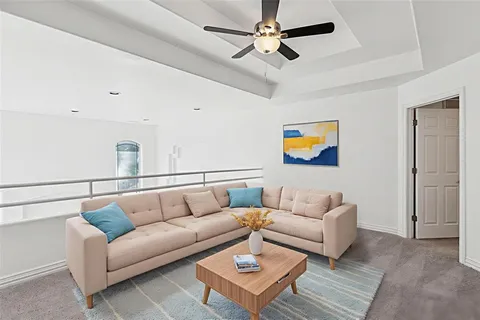 a living room with furniture and a ceiling fan