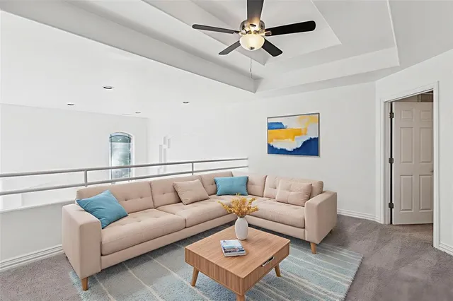 a living room with furniture and a ceiling fan