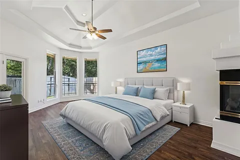a bedroom with a large bed a chandelier and windows