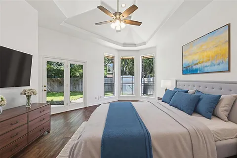 a spacious bedroom with a large bed and a flat screen tv