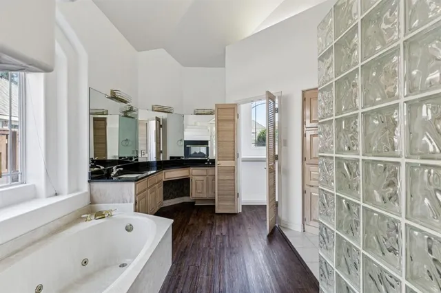 a bathroom with a double vanity sink a mirror and a bathtub