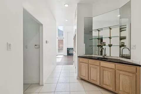 a bathroom with a granite countertop sink a mirror and a shower