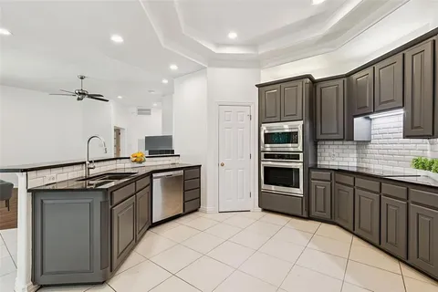 a kitchen with stainless steel appliances granite countertop a stove sink and cabinets