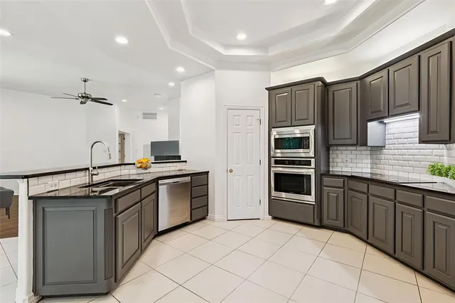 a kitchen with stainless steel appliances granite countertop a stove sink and cabinets