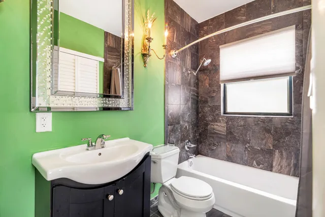 a bathroom with a sink a toilet a mirror and bathtub