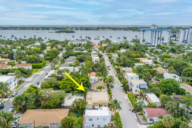 an aerial view of a city with lots of residential buildings ocean and mountain view in back