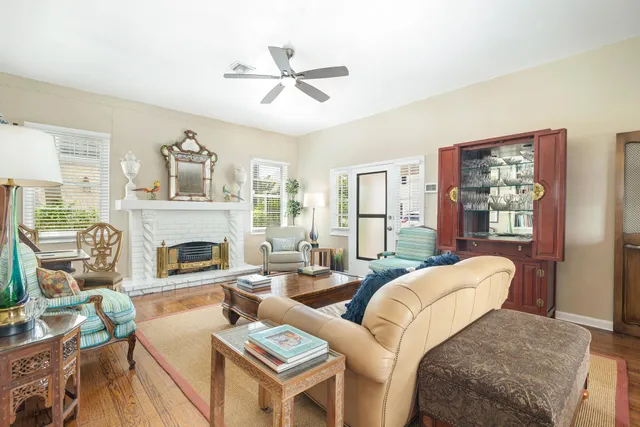 a living room with furniture a fireplace and a large window