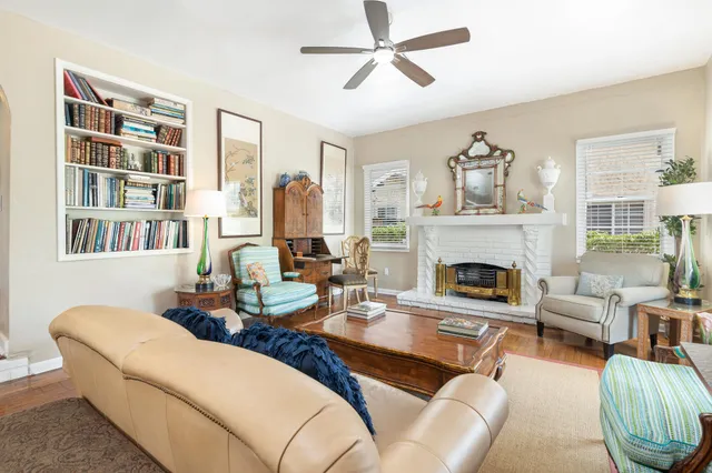 a living room with furniture a fireplace and a large window