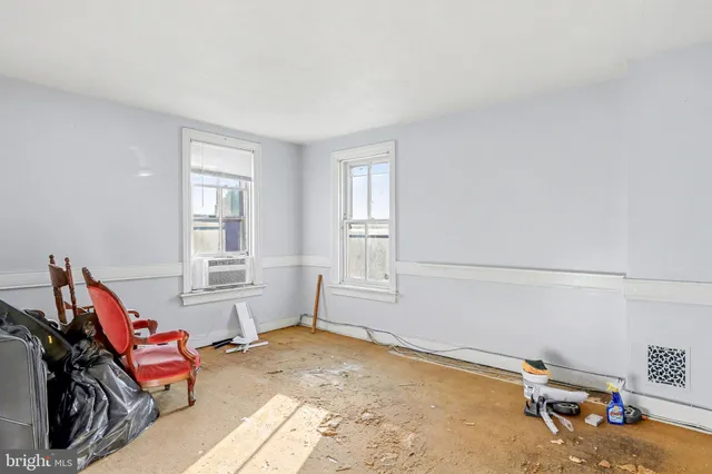 a living room with furniture a rug and white walls