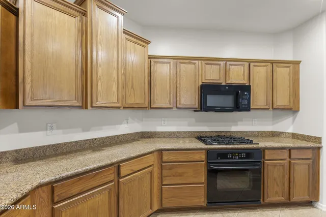 a kitchen with granite countertop white cabinets and stainless steel appliances