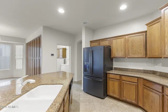 a kitchen with a refrigerator sink and cabinets