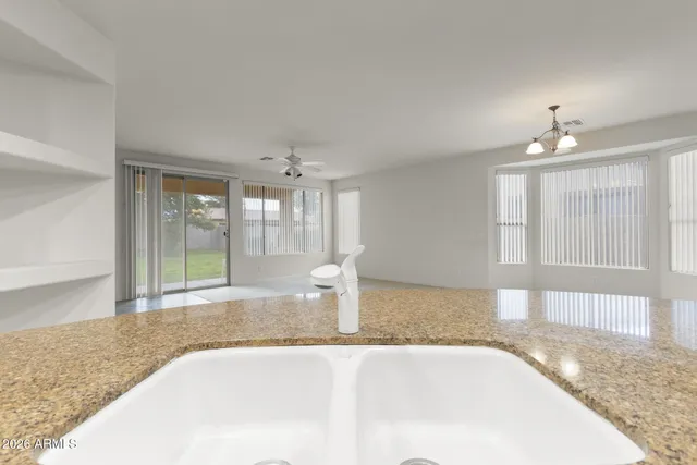 a view of a kitchen with granite countertop a sink and cabinets