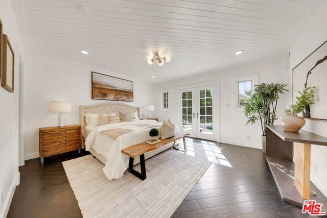 a spacious bedroom with a bed a couch and potted plant with the outer view