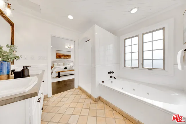 a bathroom with a bathtub sink and mirror