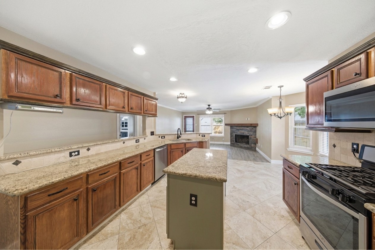 13506 Spring Court Tomball, TX 77375 - Photo 12 of 37 a kitchen with stainless steel appliances granite countertop a sink stove and refrigerator
