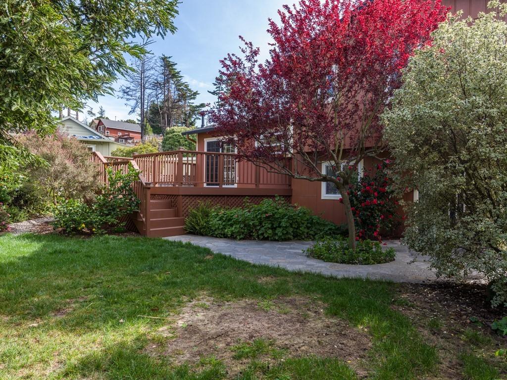 571 Lancaster Boulevard Moss Beach, CA 94038 - Photo 13 of 16 a view of a house next to a big yard and large trees
