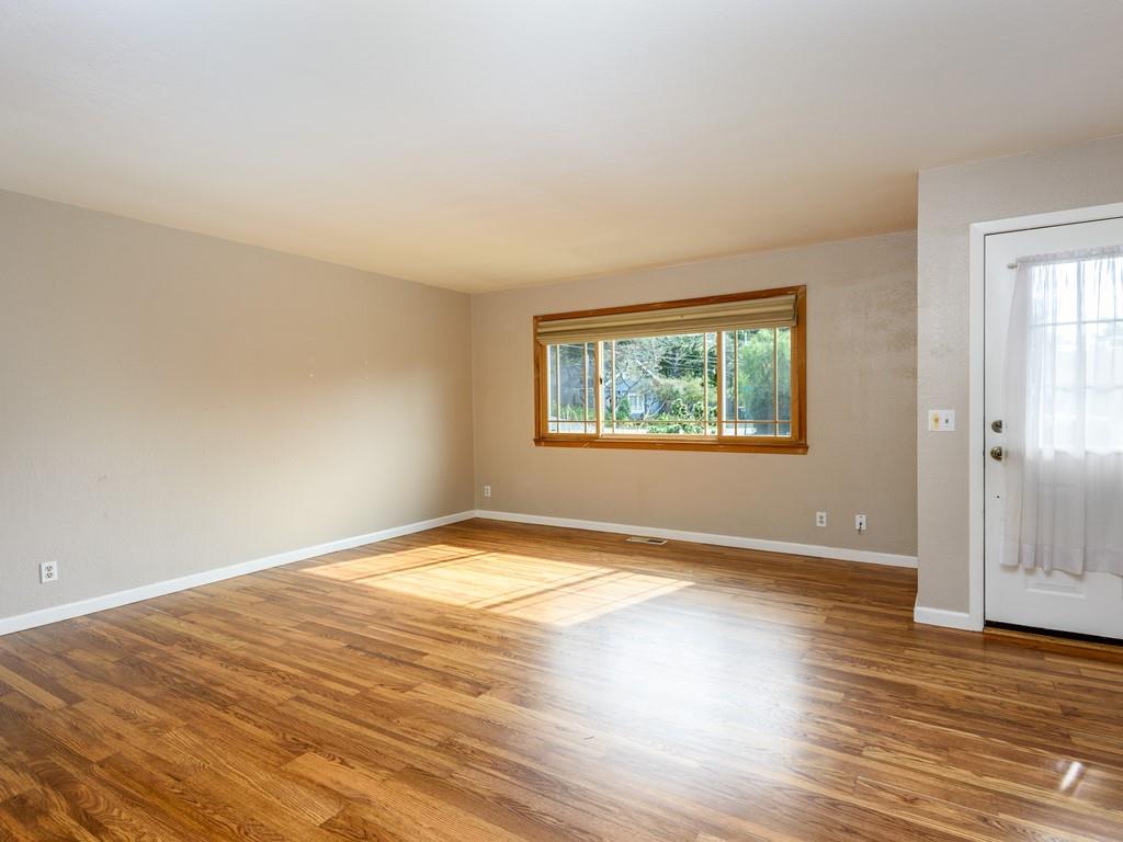571 Lancaster Boulevard Moss Beach, CA 94038 - Photo 8 of 16 an empty room with wooden floor and windows