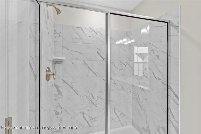 a bathroom with a glass shower door and mirror