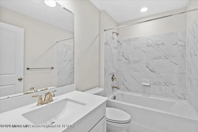 a bathroom with a sink toilet vanity and shower