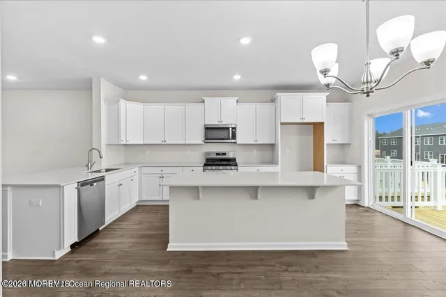 a kitchen with stainless steel appliances granite countertop a sink a stove top oven a counter space and cabinets