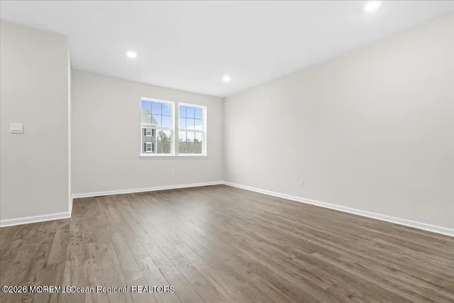 an empty room with wooden floor and window