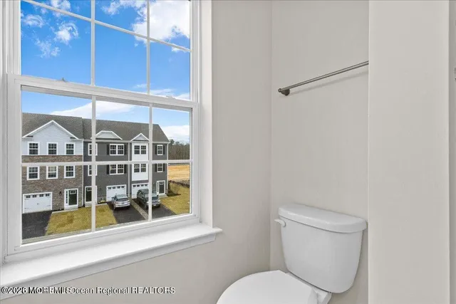 a bathroom with a toilet a sink and a window