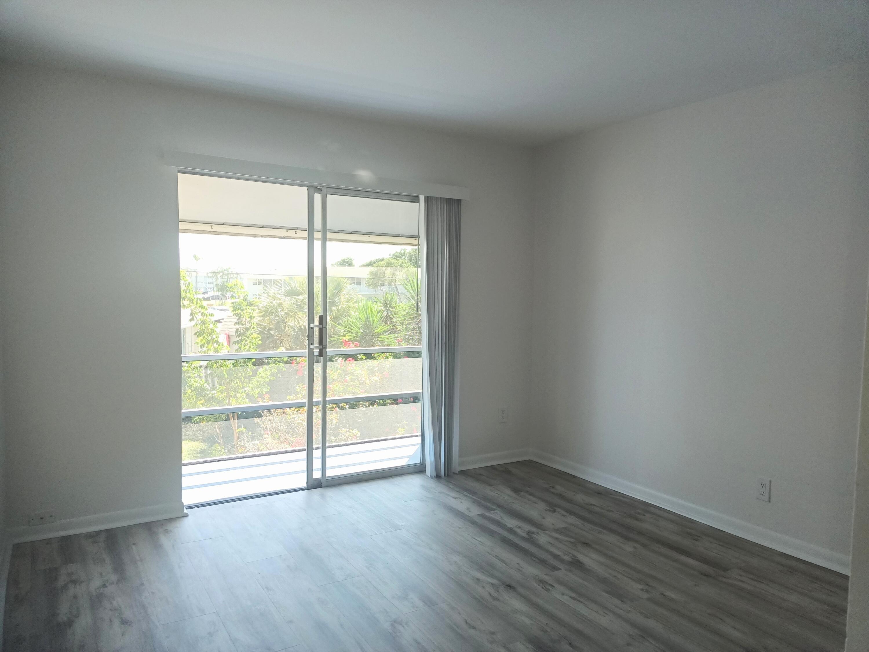 640 Southeast 2nd Avenue, Unit 202 Boynton Beach, FL 33435 - Photo 11 of 21 a view of a room with wooden floor and doors