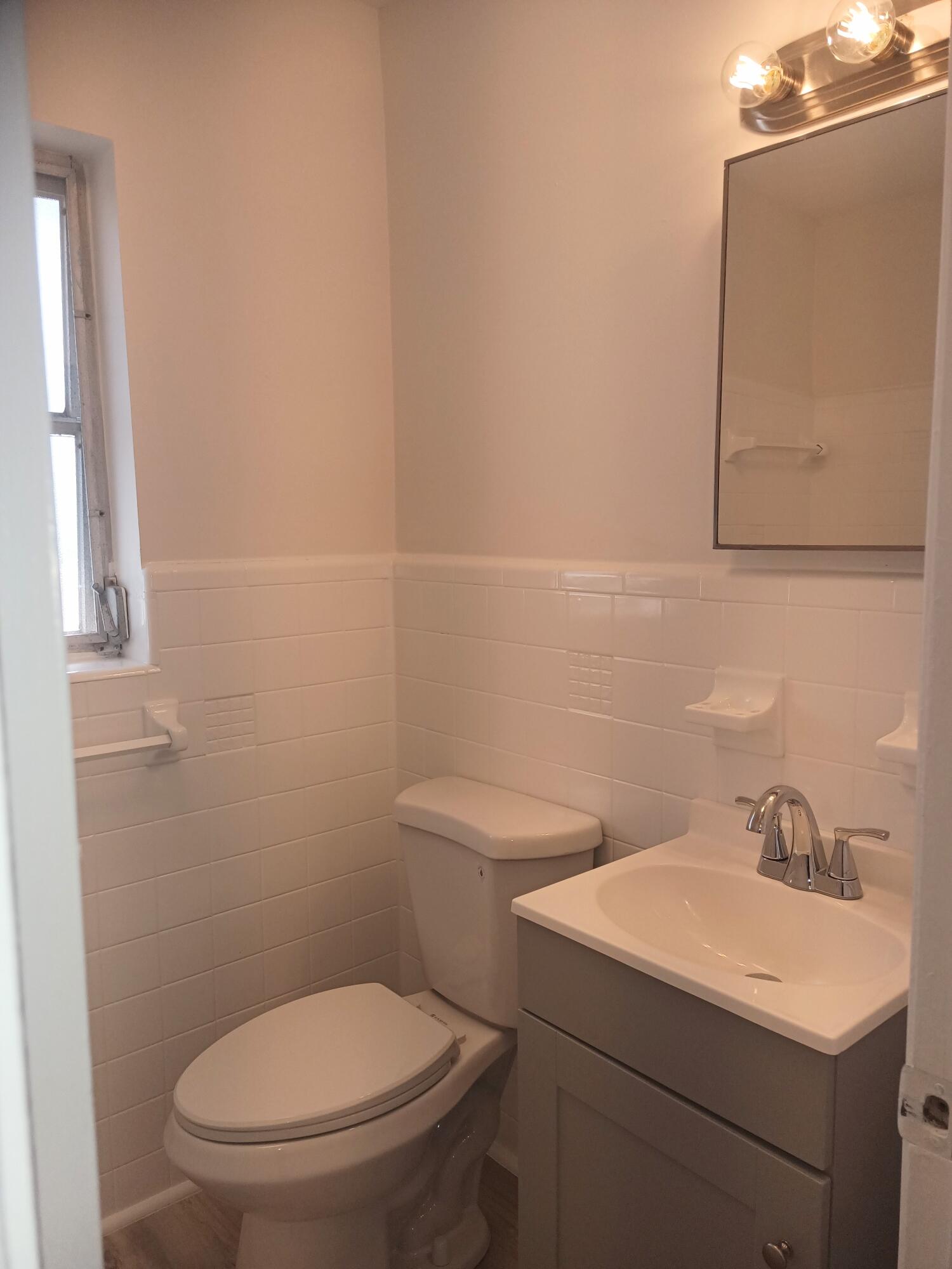 640 Southeast 2nd Avenue, Unit 202 Boynton Beach, FL 33435 - Photo 14 of 21 a bathroom with a toilet sink and mirror