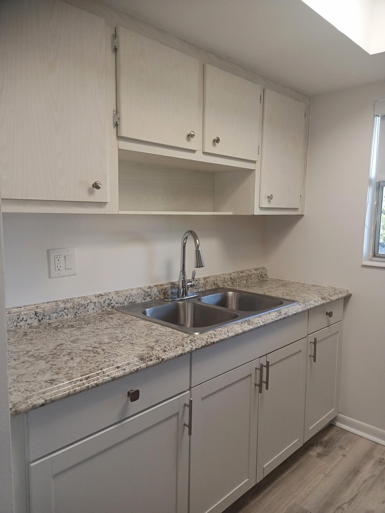 640 Southeast 2nd Avenue, Unit 202 Boynton Beach, FL 33435 - Photo 4 of 21 a kitchen with granite countertop white cabinets and a sink