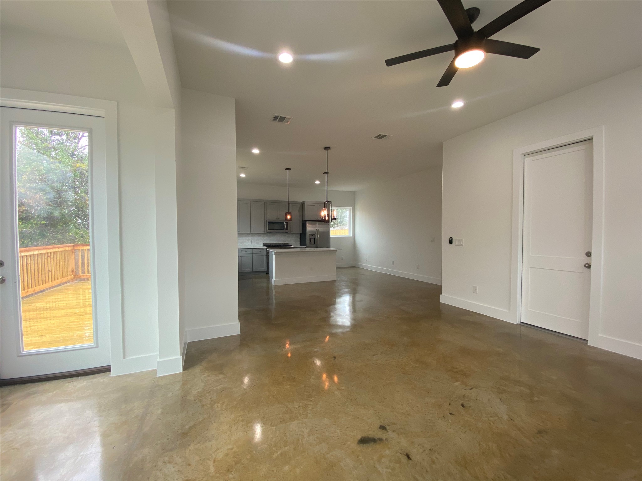 1916 Webberville Road, Unit B Austin, TX 78721 - Photo 10 of 25 Open-concept living area featuring polished concrete flooring, a modern ceiling fan with integrated lighting, and recessed ceiling lighting