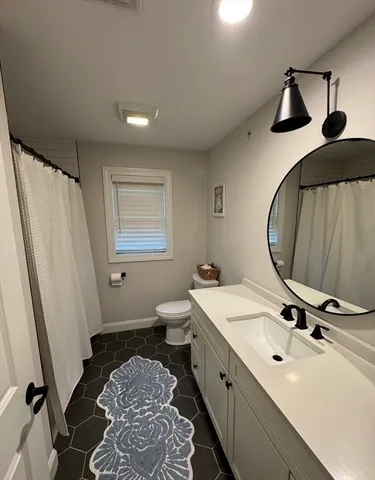 a bathroom with a sink and mirror with bathtub
