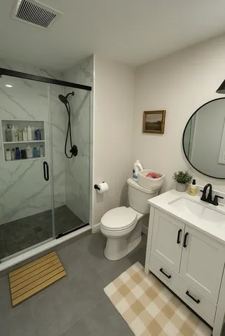 a bathroom with a toilet sink shower and mirror