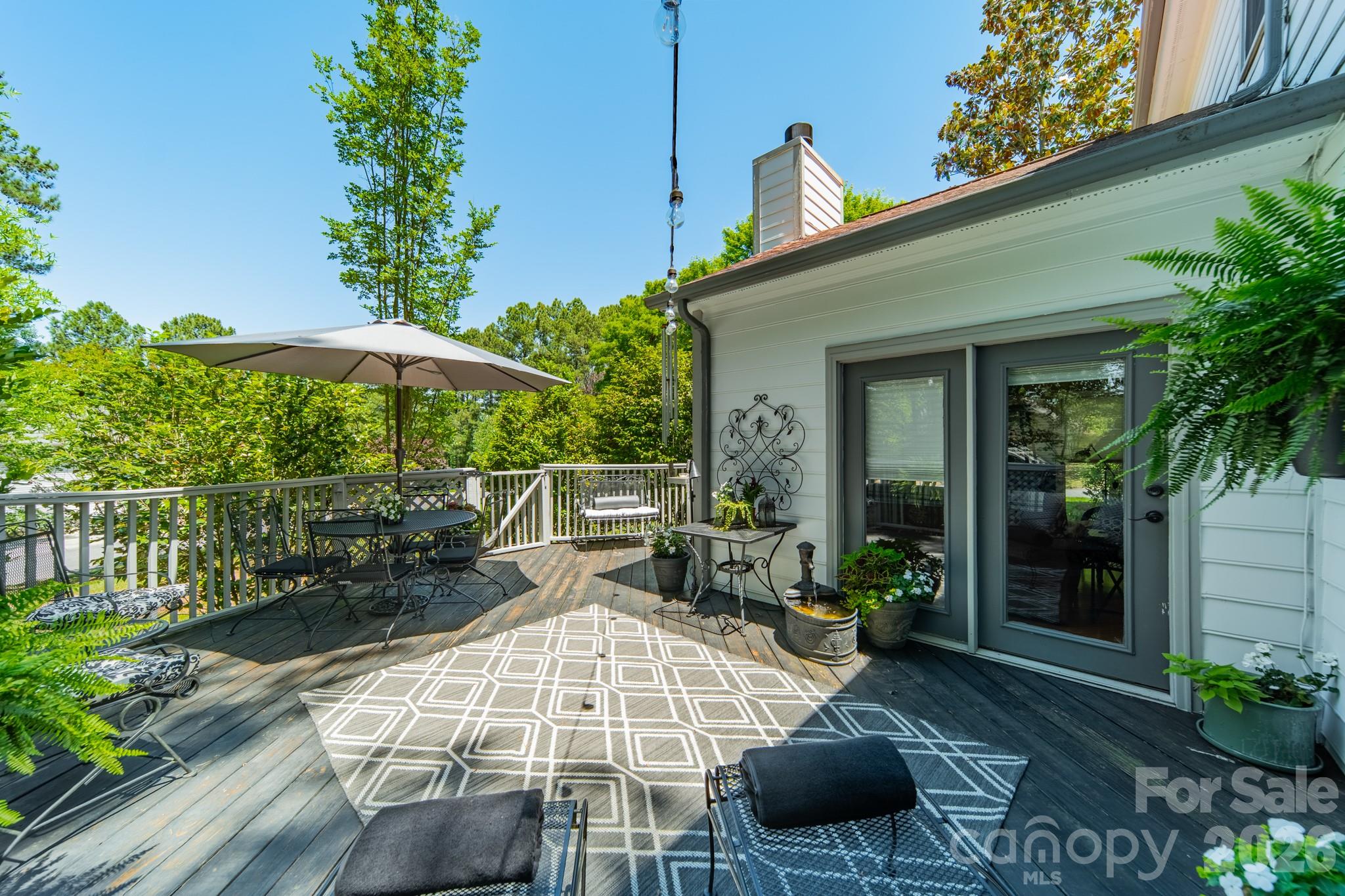 11043 Seven Coves Drive Tega Cay, SC 29708 - Photo 8 of 45 a view of a patio with table and chairs potted plants with wooden fence