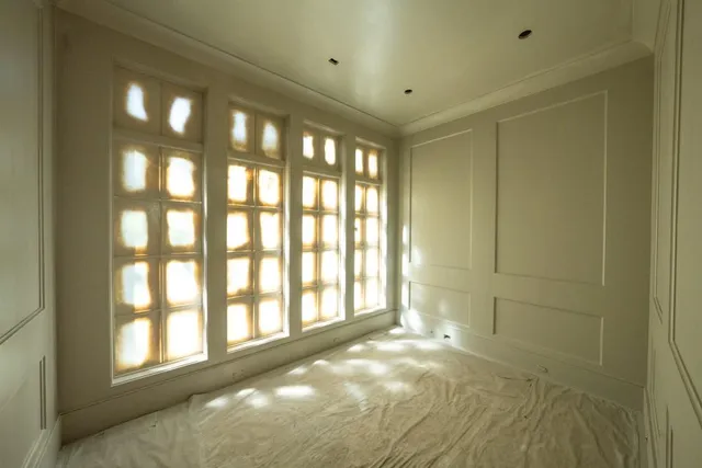 a large kitchen with kitchen island a large window a sink and stainless steel appliances