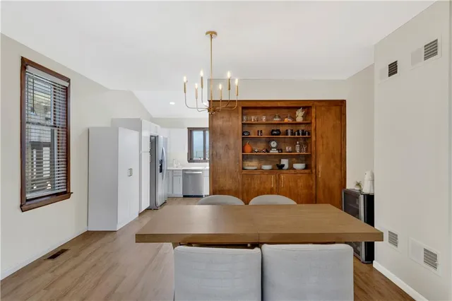 a kitchen with a table chairs and refrigerator