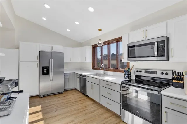 a kitchen with stainless steel appliances granite countertop a refrigerator and a stove top oven