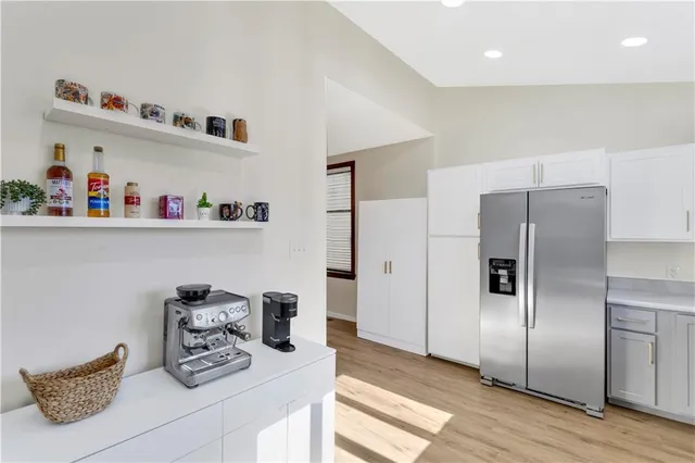 a kitchen with refrigerator and wooden floor