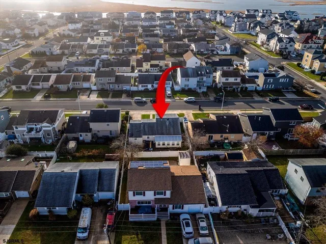 an aerial view of a house with garden space and a swimming pool