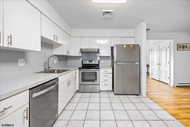 a kitchen with a stove a refrigerator and a sink