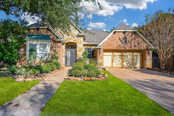 a front view of a house with a garden and plants
